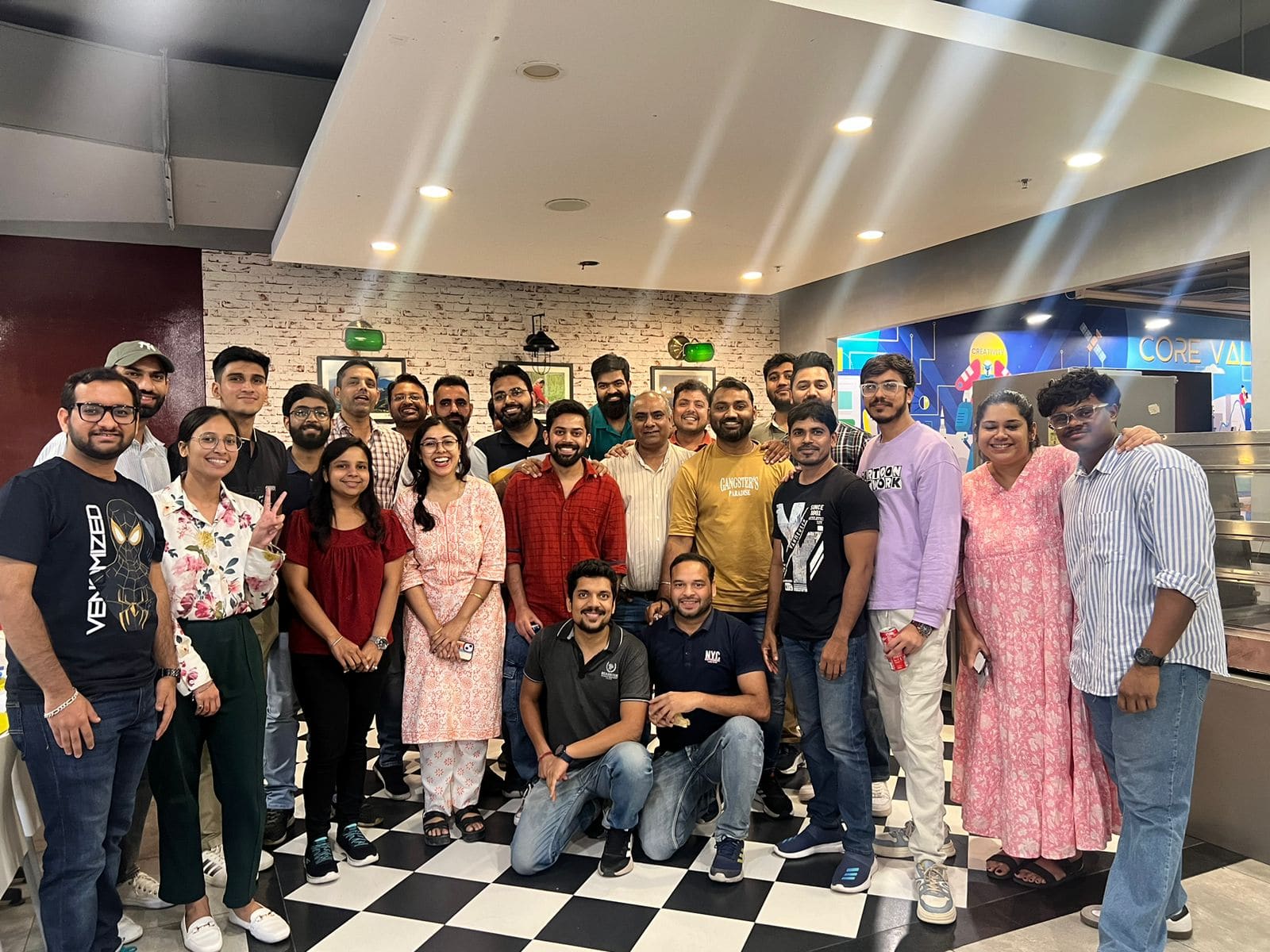 Group photo of the MakeMyTrip design team in the office cafeteria