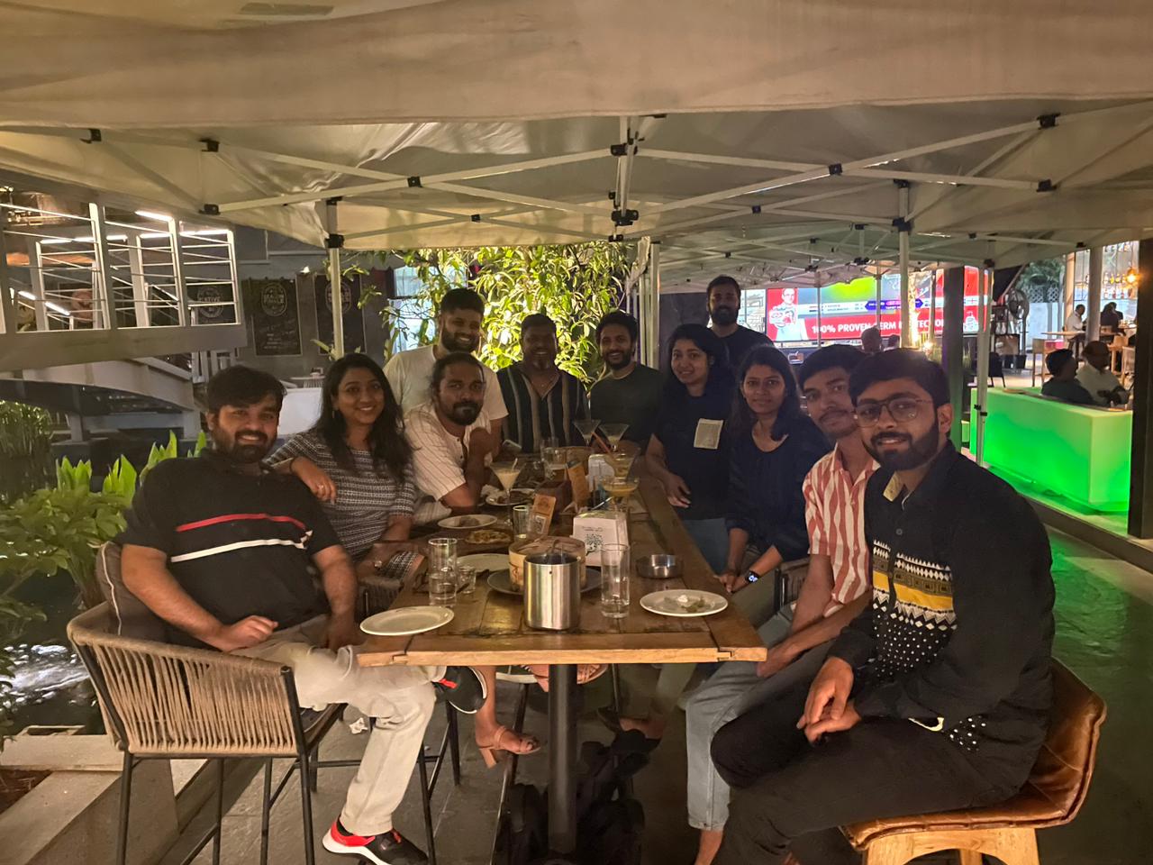 redBus teammates around a dinner table at an outdoor restaurant